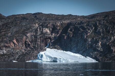 Huge floating iceberg in deep blue ocean water. Greenland and Antarctica, near Ilulissat. Global...