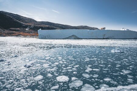 Huge floating iceberg in deep blue ocean water. Greenland and Antarctica, near Ilulissat. Global...