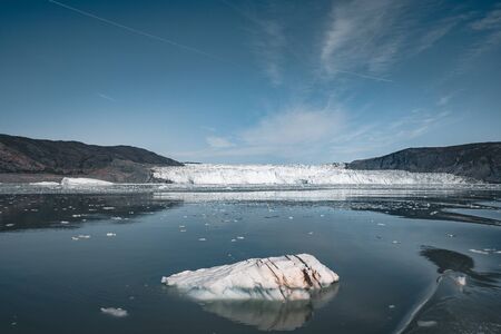 Greenland, Eqip Sermia, Eqi Glacier in Greenland Disko Bay. Boat trip in the morning over the arctic sea,Baffin Bay, calving glacier. Ice breaking of on a blue sky wth clouds. Photo taken in Greenland.の写真素材