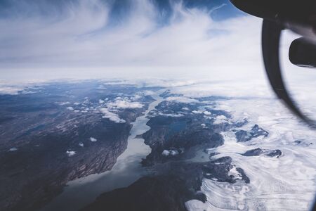 Greenland, aerial view of glacier and snow covered mountains. This is a consequence of the...