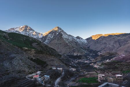 Morocco The High Atlas Mountain range between Marrakesh, Ait Ben Haddou and Ouarzazate. Sunrise and sunset with village in front. Blue sky during twilight.の写真素材