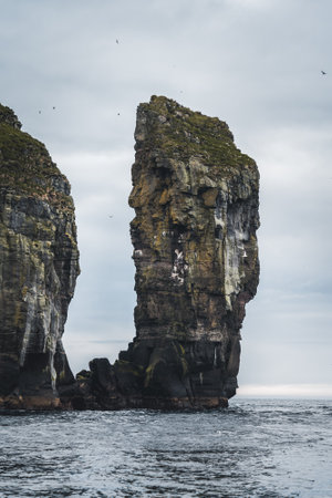 Close-up shot of famous Drangarnir cliff with Tindholmur islands in the background taken during early morning hike in spring at Faroese coastline Faroe Island, Denmark, Europeの写真素材