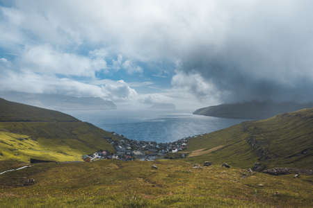 Sun shining on small village on the the northern most village on Stremoy in the Faroe Islands with...