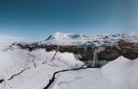 The beautiful Seljalandsfoss in Iceland during winter covered with snow.の写真素材