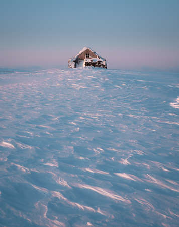Fantastic winter landscape panorama with wooden house in snowy mountains. Snow covered hut. Christmas holiday and winter vacations conceptの写真素材
