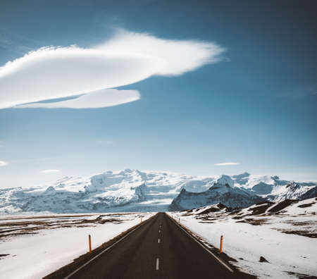 Street Highway Ring road No.1 in Iceland, with view towards massive glacier with beautiful lenticular clouds. Southern side if the country. Road trip travel concept.の写真素材