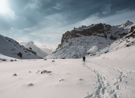 Two friends hiking in and winter iceland nature in highlands through snow covered mountains on a...