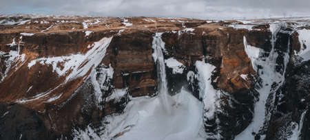Aerial drone view of Haifoss waterfall in Iceland during Winter in the Highlands. Blue sky and...
