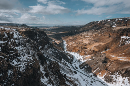 Aerial drone view of Haifoss waterfall in Iceland during Winter in the Highlands. Blue sky and...