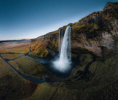 Aerial shot of Seljalandsfoss is located in the South Region on Iceland. Visitors can walk behind. Seljalandsfoss waterfall with a great sunset on popular tourist destination. Part of the golden circleの写真素材