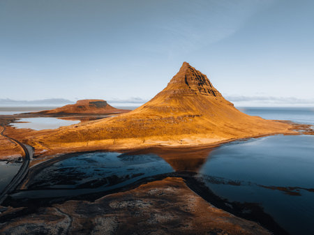 Beautiful aerial view of the Kirkjufell high mountain in Iceland, on the Snaefellsnes peninsula. Sunset Sunrise soft orange light. West Iceland.の写真素材