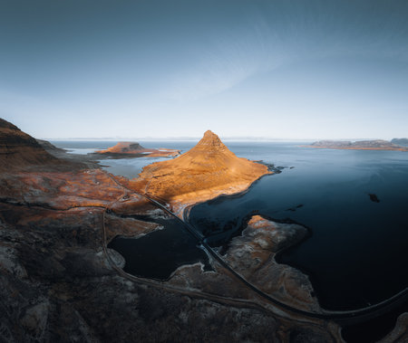 Beautiful aerial view of the Kirkjufell high mountain in Iceland, on the Snaefellsnes peninsula. Sunset Sunrise soft orange light. West Iceland.の写真素材
