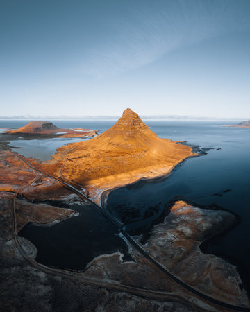 Beautiful aerial view of the Kirkjufell high mountain in Iceland, on the Snaefellsnes peninsula. Sunset Sunrise soft orange light. West Iceland.の写真素材
