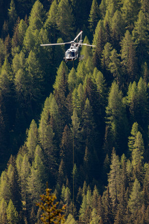 Helicopter flight transport over the forest in swiss alpsの写真素材