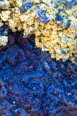 Natural elemental sulphur emerging from rocky surface in geothermal landscape, bright yellow mineral deposits on stonesの写真素材