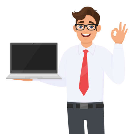 Young business man showing laptop and gesturing okay or OK sign. Handsome person carrying computer. Male character holding digital technology device. Cartoon  illustration design concept in vector.のイラスト素材