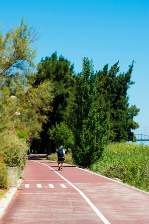 healthy man hiking on beautiful road with green landscape aheadの写真素材