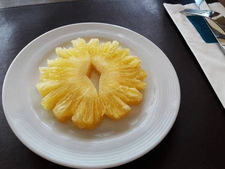 Two piece of sweet and juicy pineapples on white plateの写真素材
