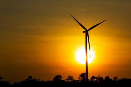 Wind turbine by sunrise on field