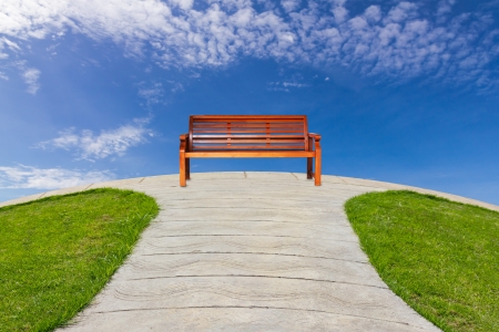 Alone bench in pathway with blue sky の写真素材