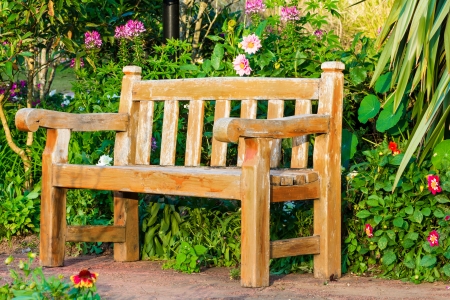 Bench in flower garden with evening lightの写真素材