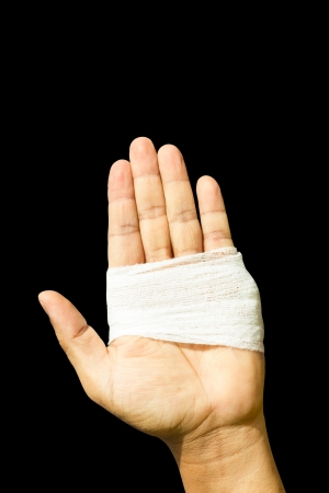 Hand up by bandage hand in black backgroundの写真素材