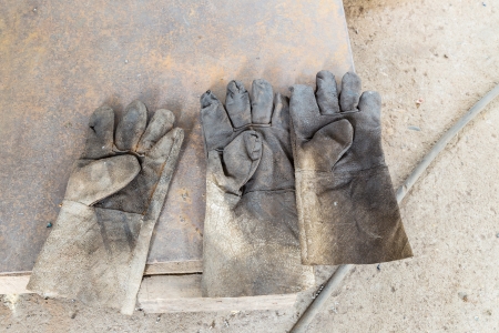 Three dirty leather gloves on floorの写真素材