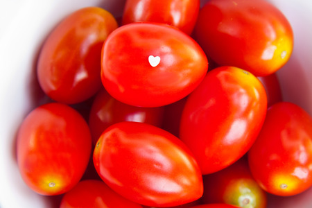 Small heart shape on red tomatoの写真素材