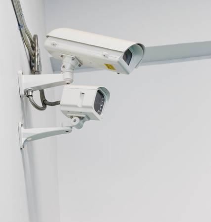 White CCTV camera and infrared light on wall
