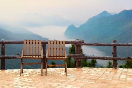 Chairs over mountain  with sky and fogの写真素材