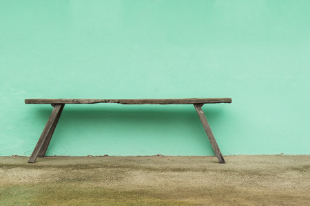 Old wooden bench and green on concrete wallの写真素材