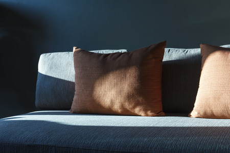 Decorative pillows and contemporary sofa near windowの写真素材