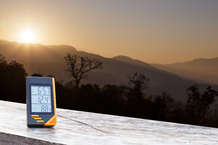 Digital display thermometer with mountain and sunlight in cold dayの写真素材