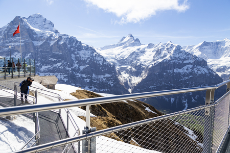 GRINDELWALD BERNE, SWITZERLAND - APRIL 24 : Traveller are resting and photograph on sky cliff walk at First peak of Alps mountain Grindelwald Switzerlandのeditorial素材