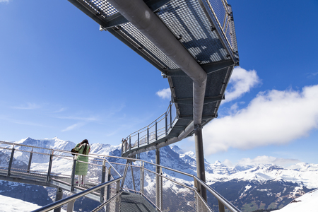 GRINDELWALD BERNE, SWITZERLAND - APRIL 24 : Traveller are resting and photograph on sky cliff walk at First peak of Alps mountain Grindelwald Switzerlandのeditorial素材