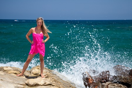 Woman standing on coast rockの写真素材