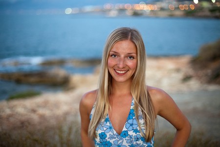 Beautiful natural woman standing on coast at eveningの写真素材