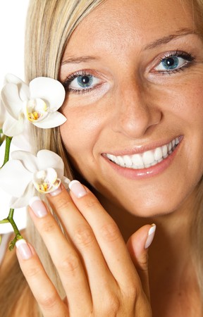 Young blond tan caucasian woman with orchid flowers isolatedの写真素材