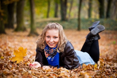 Young caucasian student girl in golden autumn parkの写真素材