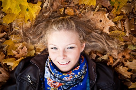 Young caucasian student girl in golden autumn park