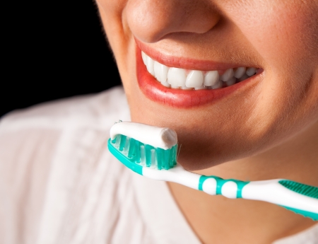 Woman healthy teeth closeup with toothbrush on black backgroundの写真素材