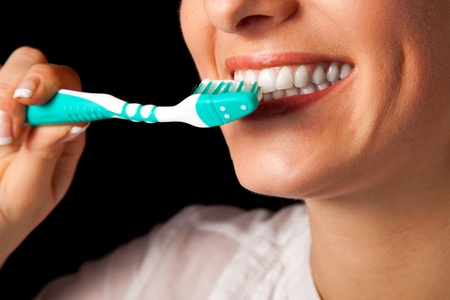 Woman healthy teeth closeup with toothbrush on black backgroundの写真素材