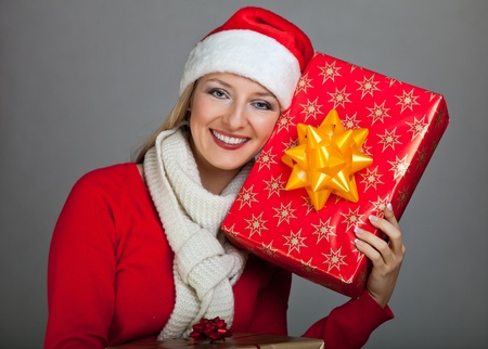 Woman in santa hat with christmas presentsの写真素材