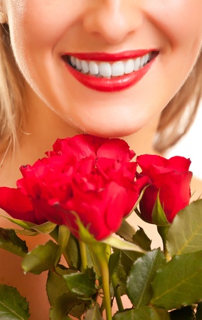 Beautiful caucasian woman with red roses on white isolated backgroundの写真素材