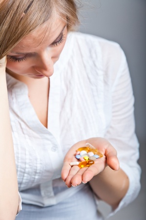 Woman holding pharmaceuticals on neutral backgroundの写真素材
