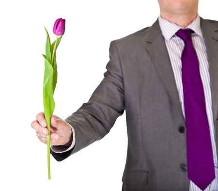 Man in suit and tie holding tulip flower isolated on whiteの写真素材