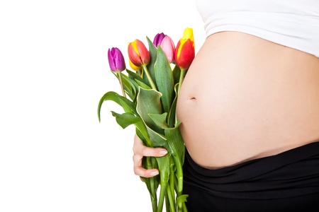 Pregnant woman belly with tulip  flowersの写真素材