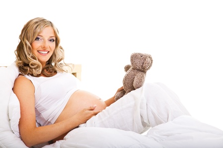 Pregnant woman in bed isolated on whiteの写真素材