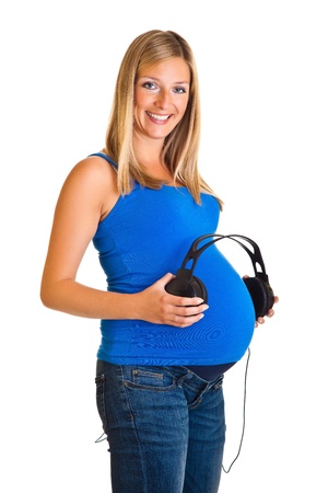 Pregnant woman with headphones isolated on whiteの写真素材