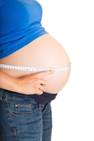 Pregnant woman measuring stomach isolated on whiteの写真素材